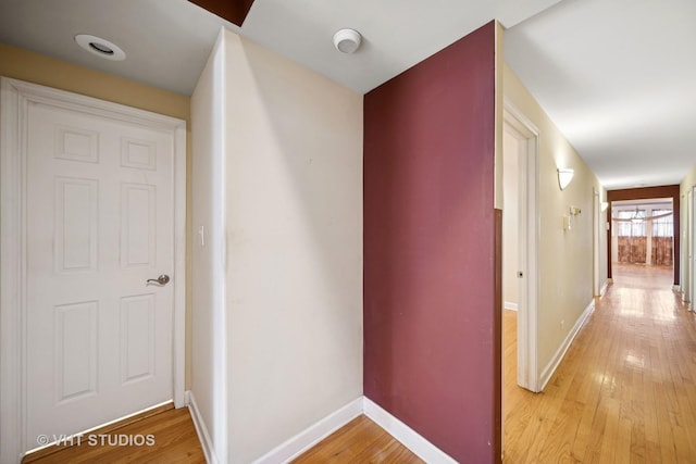 hallway featuring baseboards and light wood finished floors