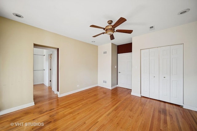 unfurnished bedroom with a closet, visible vents, light wood-style flooring, and baseboards