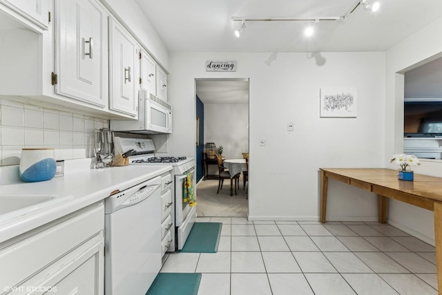 kitchen featuring light countertops, backsplash, light tile patterned flooring, white cabinets, and white appliances