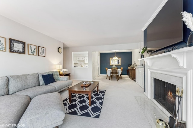 living room with light carpet, a high end fireplace, and baseboards