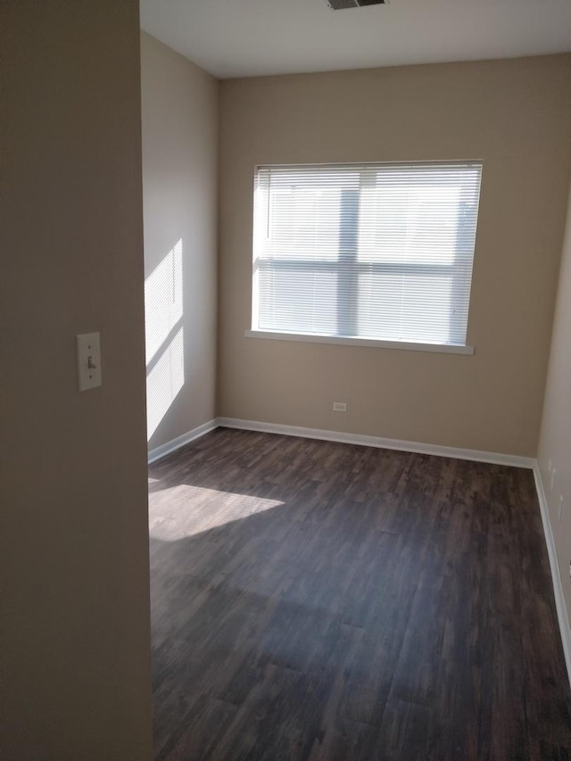 empty room with dark hardwood / wood-style flooring