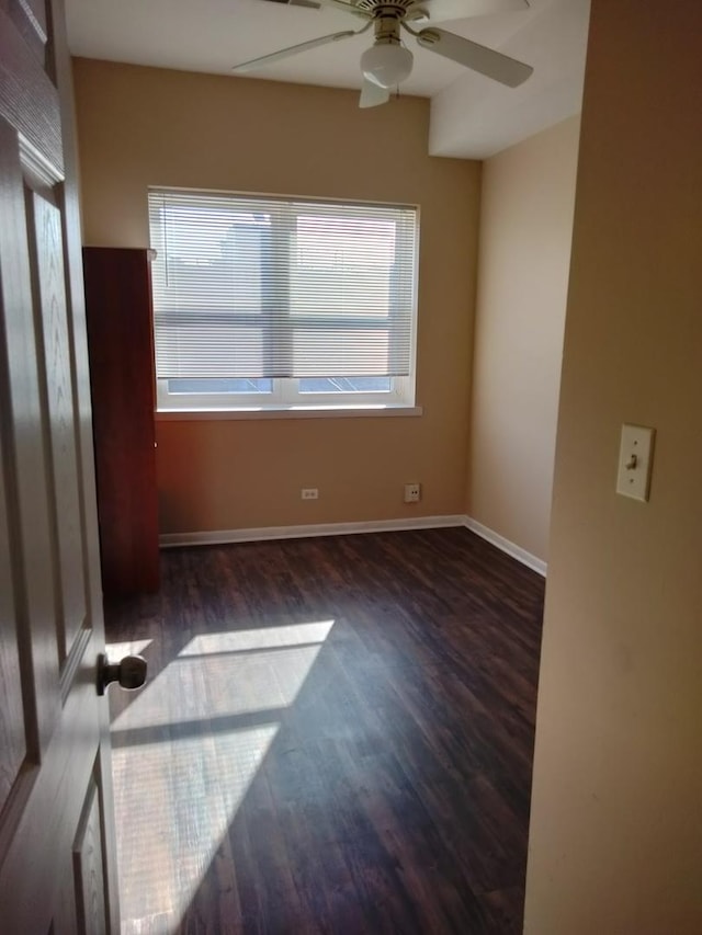 spare room featuring ceiling fan, a healthy amount of sunlight, and dark hardwood / wood-style floors