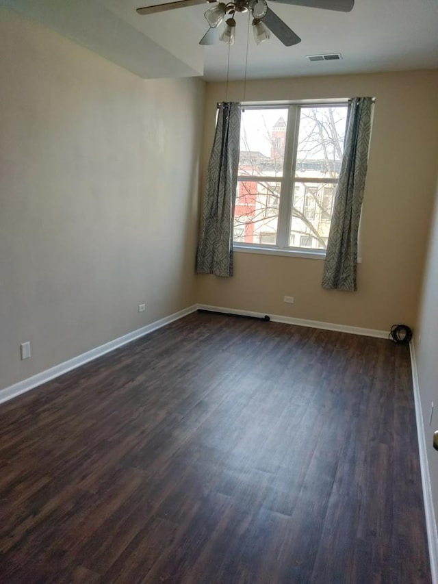 unfurnished room with dark wood-type flooring and ceiling fan