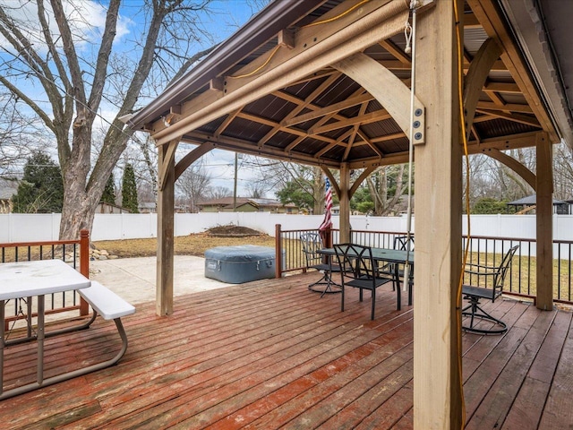 wooden deck with a hot tub and a gazebo