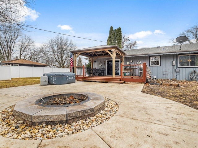 view of patio / terrace with a wooden deck, a fire pit, and a hot tub