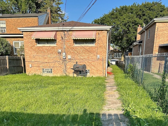 rear view of house featuring a yard