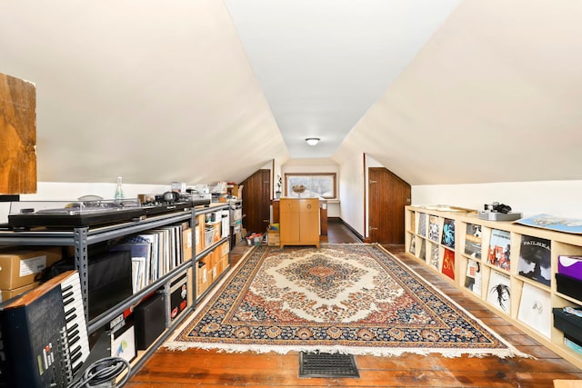 additional living space with hardwood / wood-style flooring and lofted ceiling