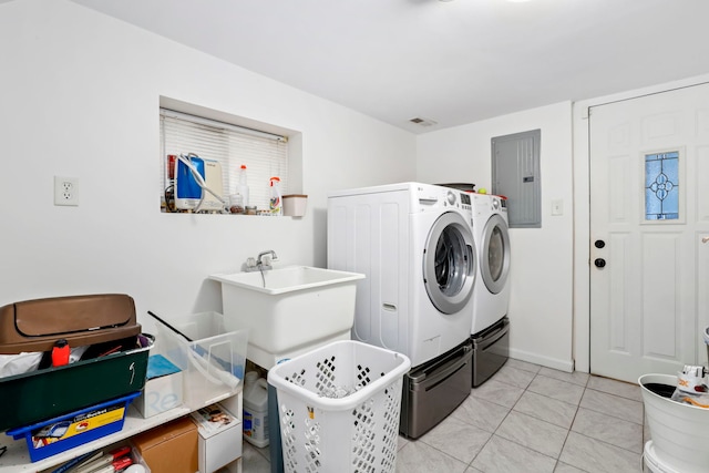 laundry room with light tile patterned flooring, electric panel, sink, and washer and dryer