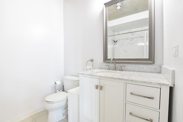 bathroom with vanity, tile patterned floors, toilet, and tiled shower