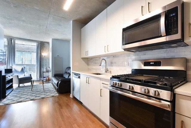 kitchen with white cabinetry, sink, light hardwood / wood-style flooring, and stainless steel appliances