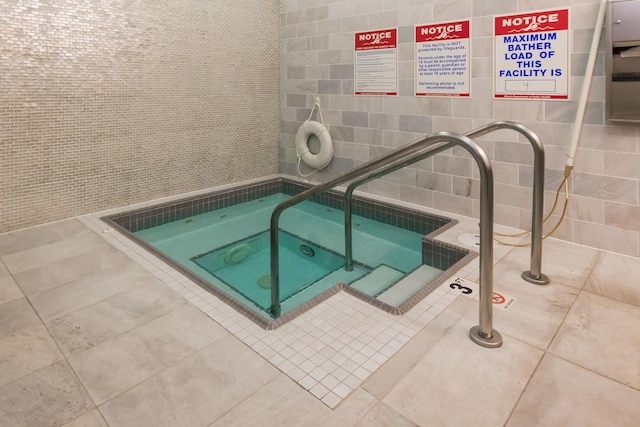 view of swimming pool featuring an indoor hot tub