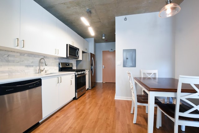 kitchen with sink, white cabinetry, stainless steel appliances, electric panel, and decorative light fixtures