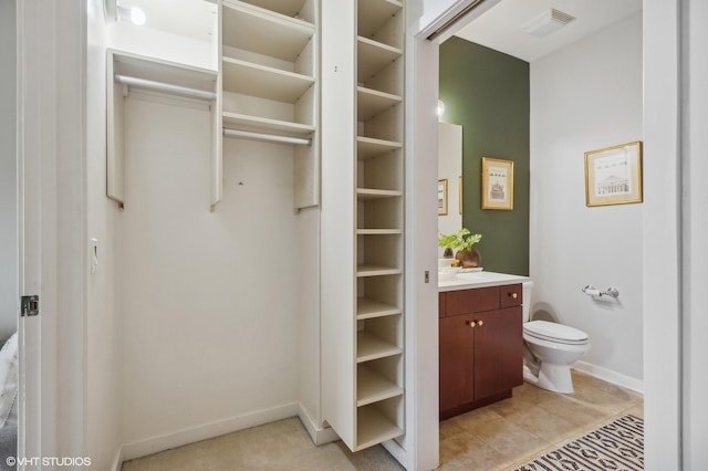 bathroom featuring tile patterned flooring, vanity, and toilet