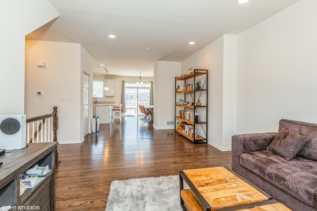 living area featuring recessed lighting, a chandelier, baseboards, and dark wood-style floors