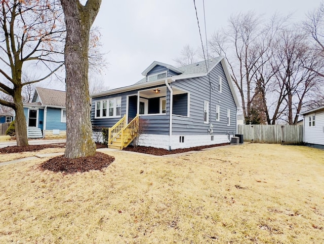 bungalow-style house featuring cooling unit and a front lawn