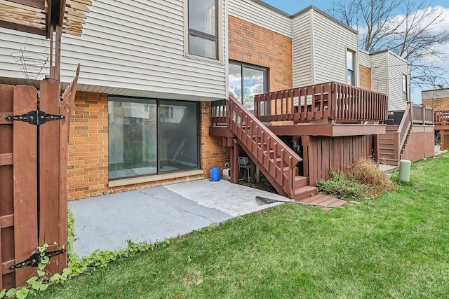 rear view of property with a wooden deck, a yard, and a patio