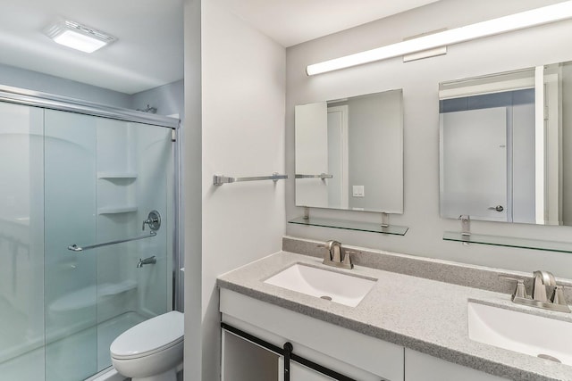 bathroom with toilet, vanity, and walk in shower