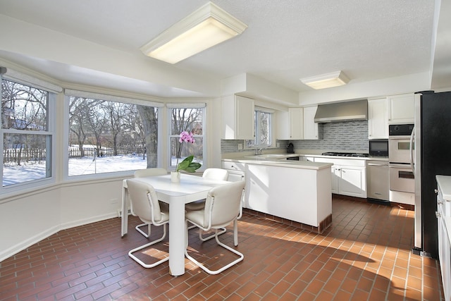 kitchen featuring white cabinetry, sink, decorative backsplash, and wall chimney exhaust hood