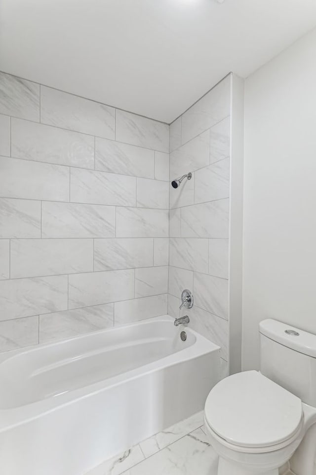 bathroom featuring tiled shower / bath and toilet