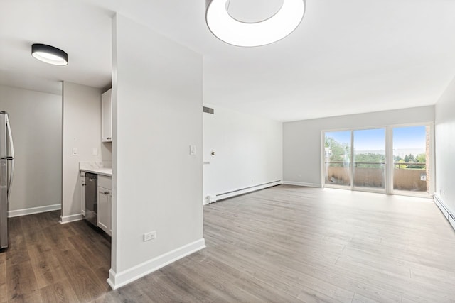 unfurnished living room with hardwood / wood-style flooring and a baseboard radiator