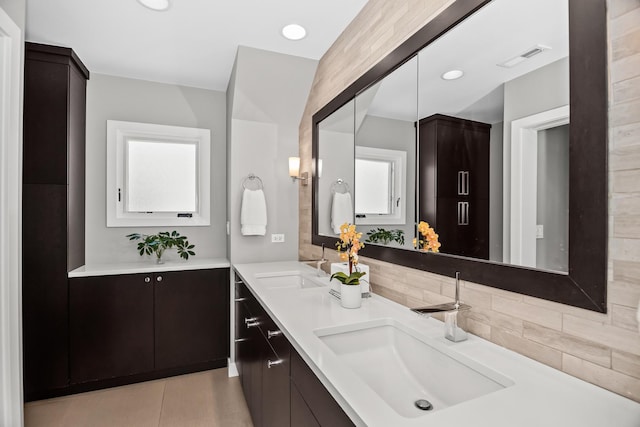 1319 Lincoln St, Evanston, IL 60201 - bathroom with visible vents, a sink, backsplash, and double vanity