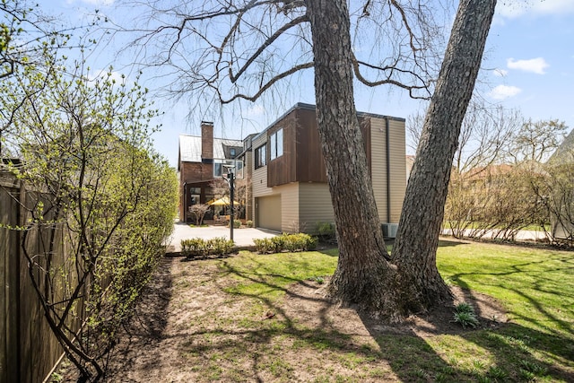 1319 Lincoln St, Evanston, IL 60201 - view of side of home with a chimney, driveway, a lawn, and a garage