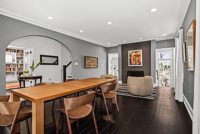 1319 Lincoln St, Evanston, IL 60201 - dining area with recessed lighting, ornamental molding, arched walkways, a brick fireplace, and dark wood-style flooring