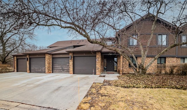 view of front of house with a garage, concrete driveway, and brick siding