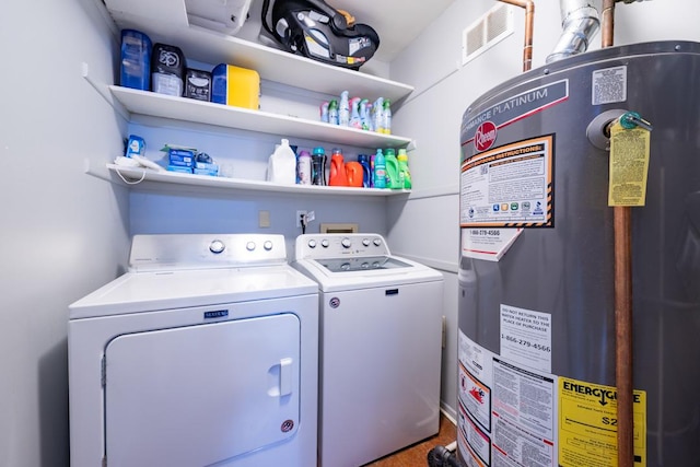 clothes washing area featuring laundry area, separate washer and dryer, gas water heater, and visible vents