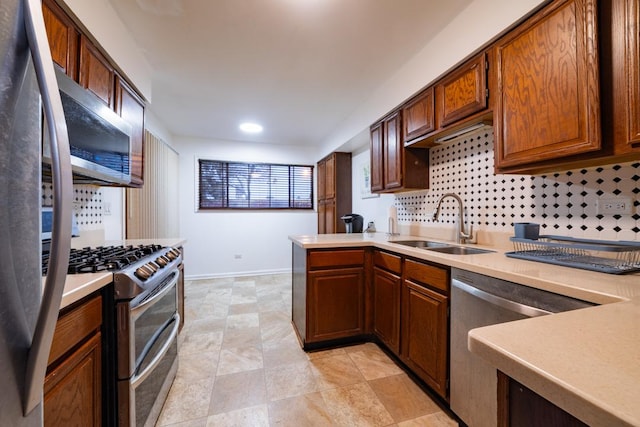 kitchen with stainless steel appliances, light countertops, a sink, and backsplash