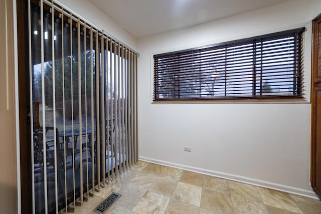 unfurnished room with visible vents and baseboards