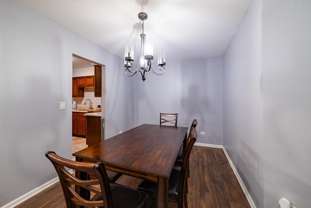 dining space with dark wood-style floors, baseboards, and an inviting chandelier