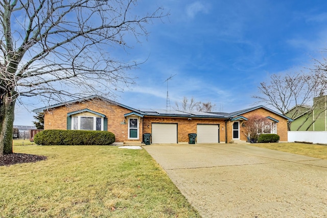 single story home with a garage, a front lawn, and solar panels