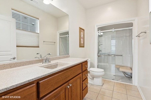 bathroom with vanity, walk in shower, tile patterned floors, and toilet