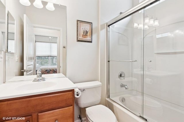 full bathroom with vanity, enclosed tub / shower combo, and toilet