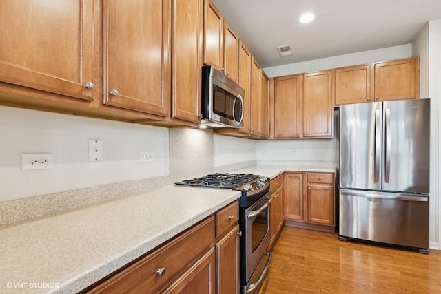 kitchen featuring light hardwood / wood-style floors and appliances with stainless steel finishes