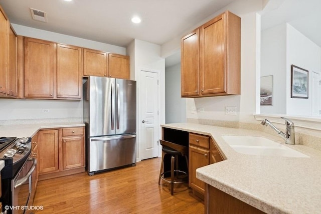 kitchen featuring sink, light hardwood / wood-style flooring, and stainless steel appliances