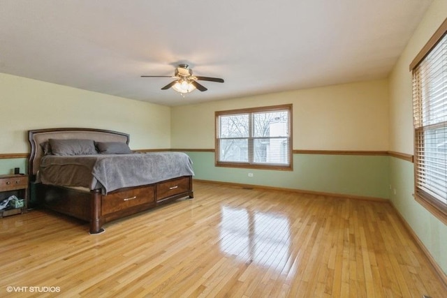 bedroom with multiple windows, light hardwood / wood-style flooring, and ceiling fan