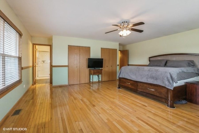 unfurnished bedroom with multiple closets and light hardwood / wood-style floors