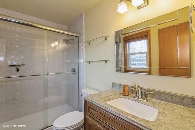 bathroom featuring vanity, an enclosed shower, and toilet