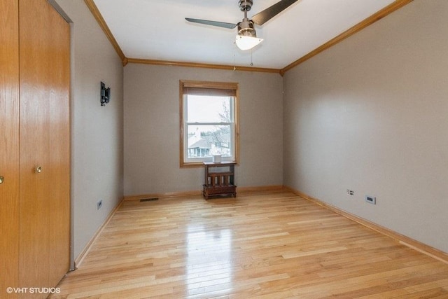 spare room featuring ceiling fan, ornamental molding, and light hardwood / wood-style flooring