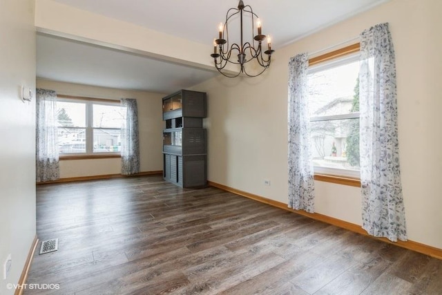 unfurnished dining area with dark hardwood / wood-style flooring and a chandelier