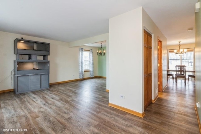 unfurnished living room featuring dark wood-type flooring and a chandelier