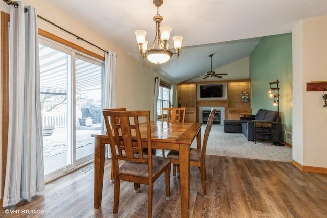 dining space featuring ceiling fan with notable chandelier, lofted ceiling, and hardwood / wood-style floors