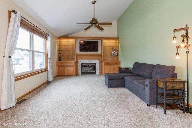 carpeted living room with ceiling fan and vaulted ceiling