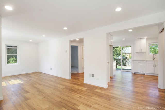 unfurnished room with sink and light hardwood / wood-style flooring