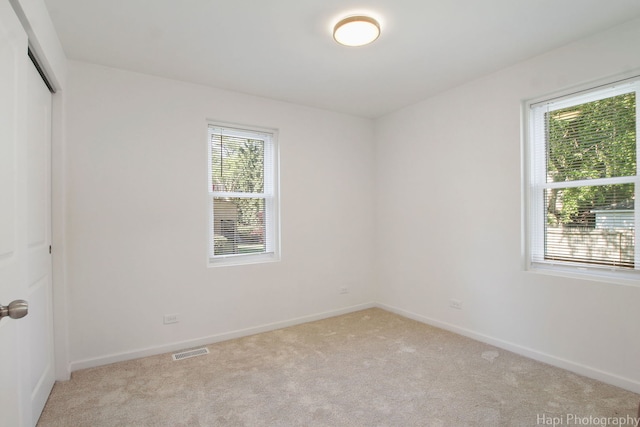 carpeted empty room featuring plenty of natural light