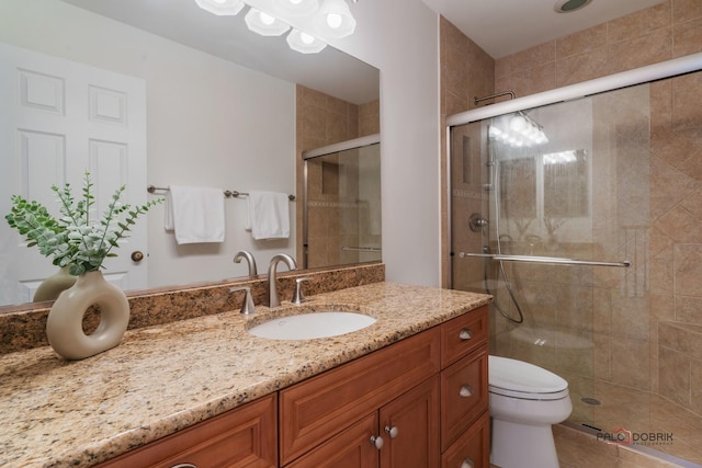 bathroom with vanity, toilet, and a shower with shower door