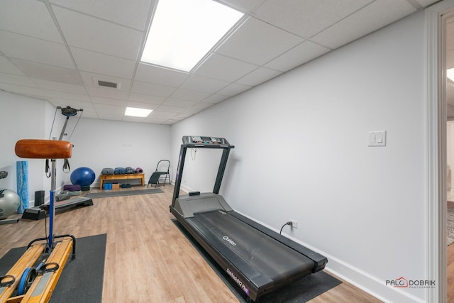 workout area with a drop ceiling and hardwood / wood-style floors