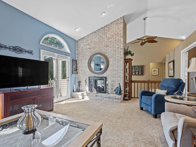 living room featuring ceiling fan, high vaulted ceiling, carpet floors, and a brick fireplace